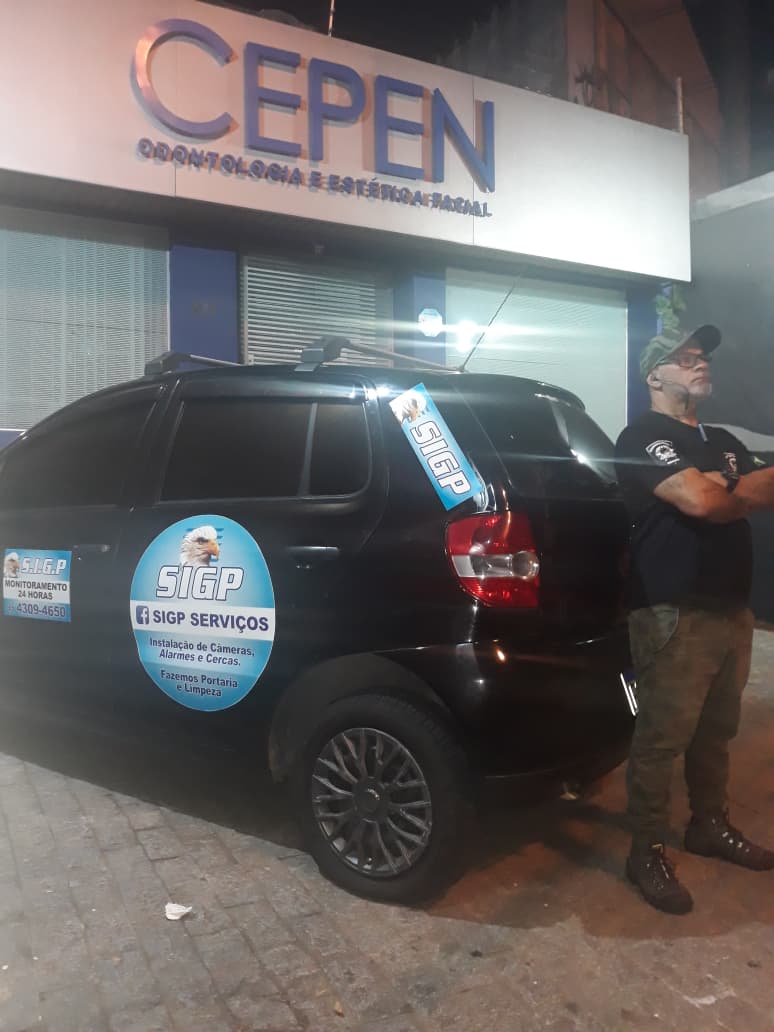 Viatura da SIGP em ronda noturna com vigilante em frente ao ponto atendido