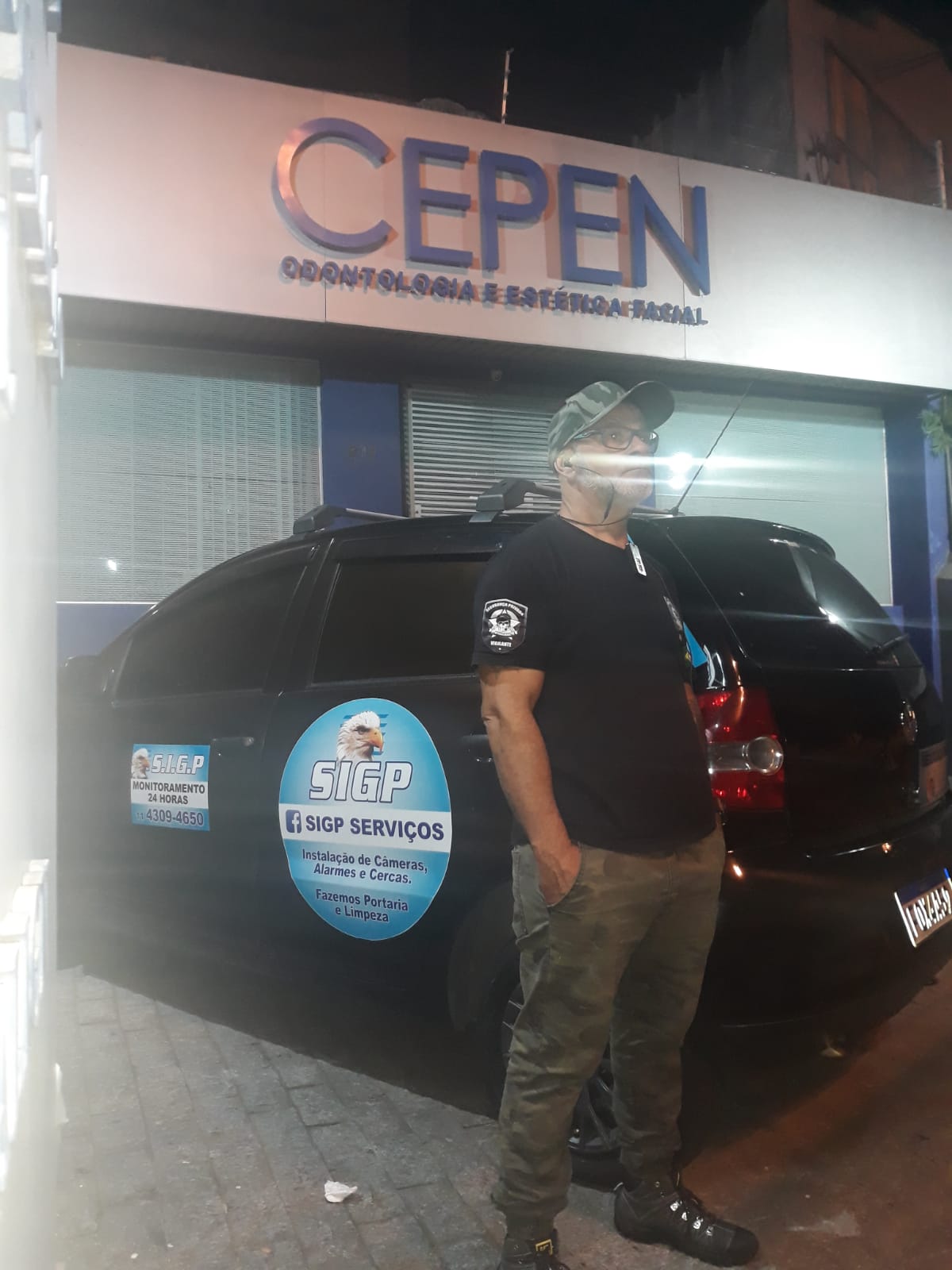 Vigilante da SIGP ao lado da viatura adesivada durante a ronda